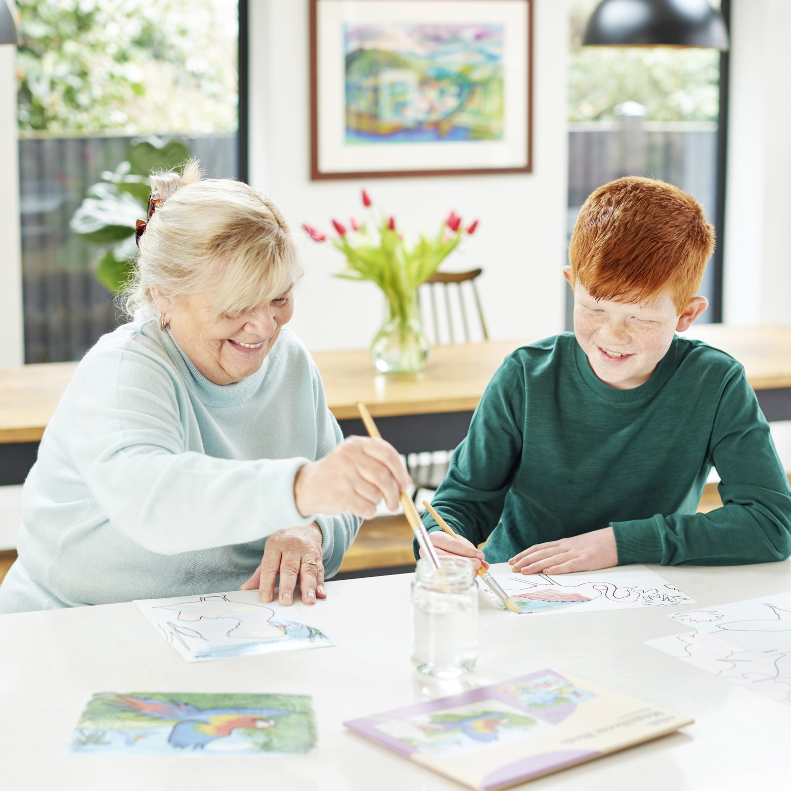 Woman and boy using water to reveal aquapaint pictures