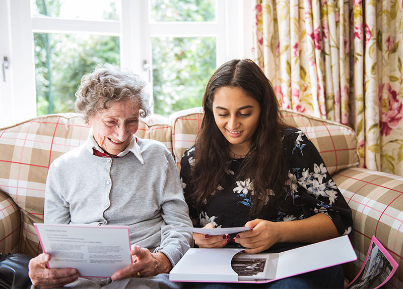 A carer going through paperwork with their patient smiling and talking
