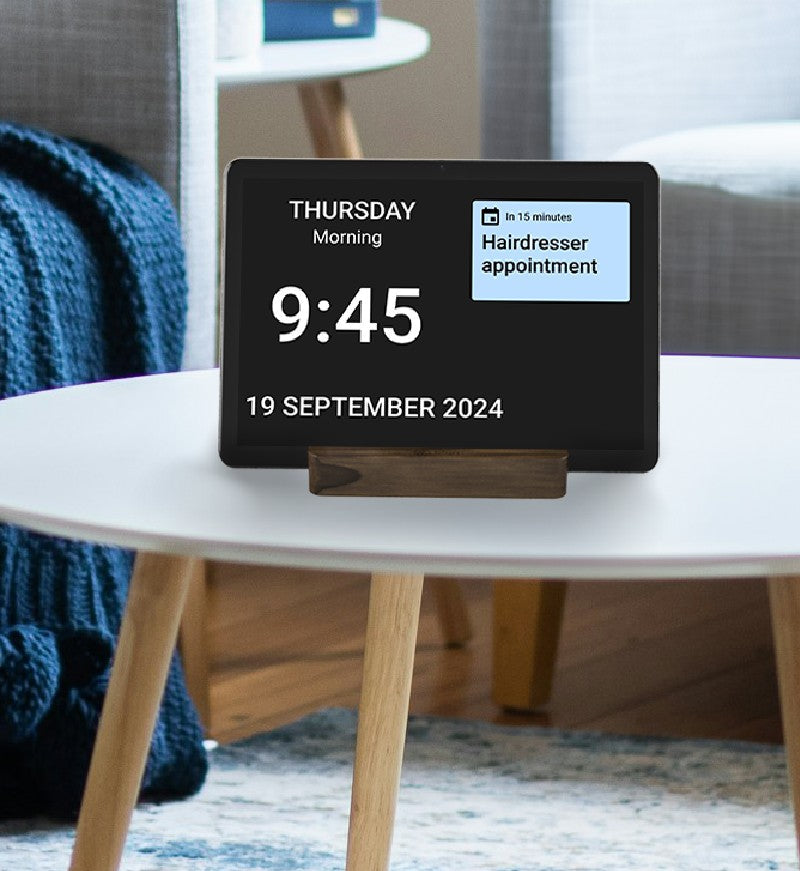 Digital tablet with white clock numbers and date on a black background and blue sticky note style reminders