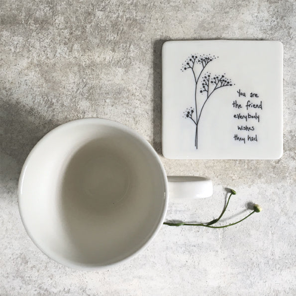 A square coaster with flower design and message &#39;you are the friend everyone wishes they had&#39; and a mug view and real flower in the photo.