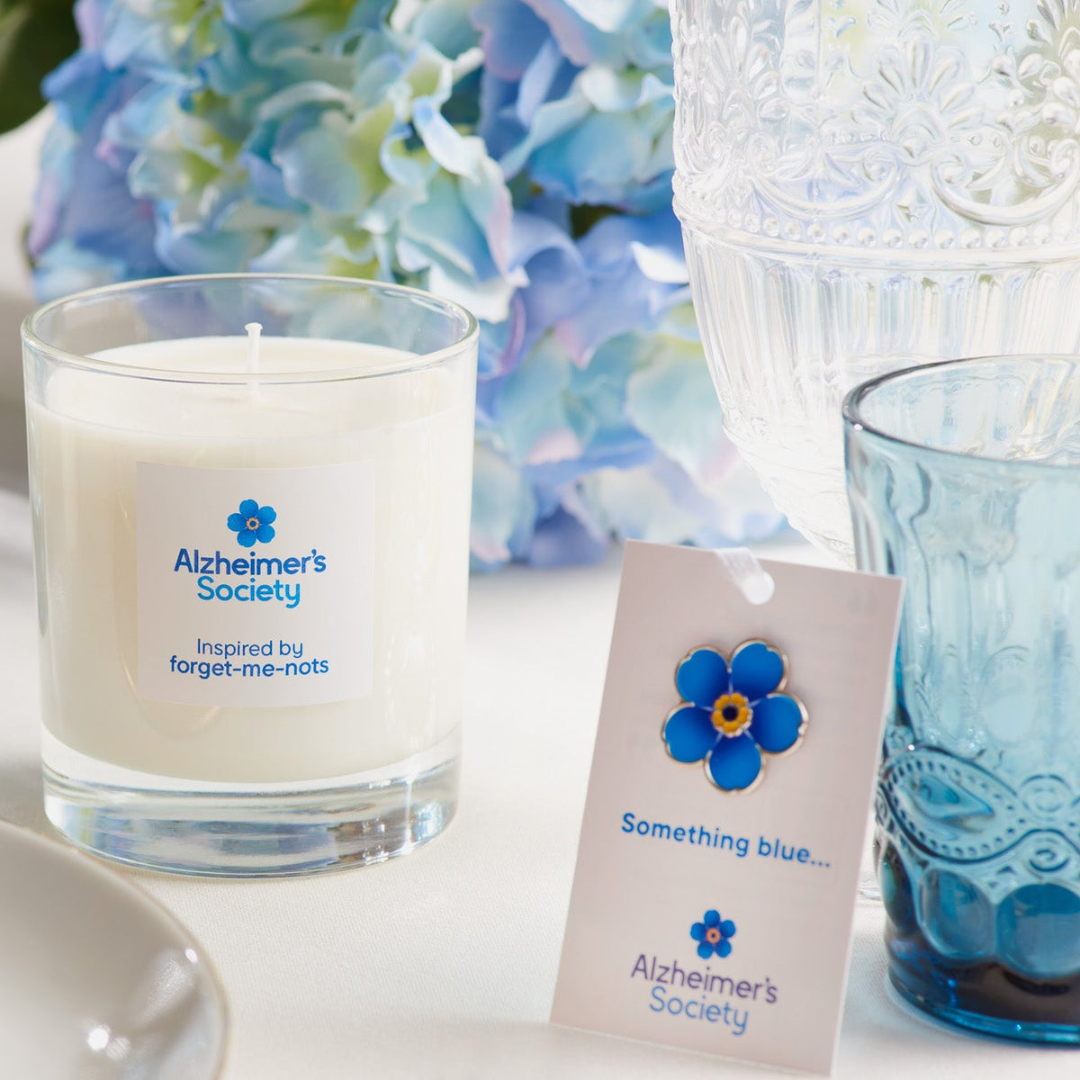 Alzheimer&#39;s Society flower favour pin on a gift card and a forget-me-not inspired scented candle