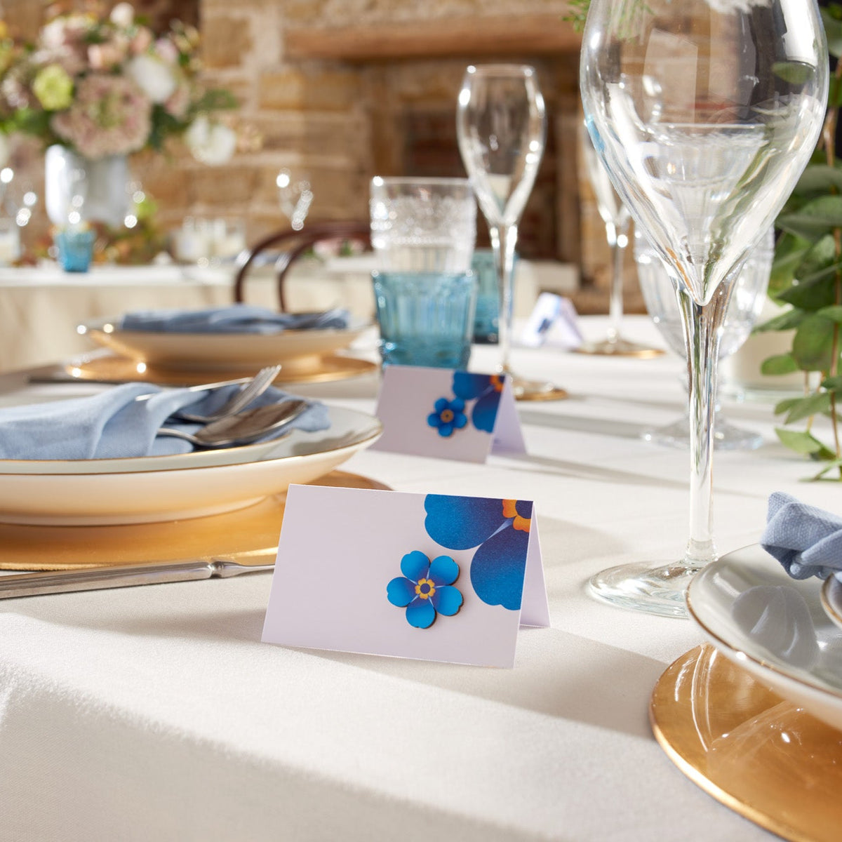 Small wooden pin badge on a forget-me-not table card