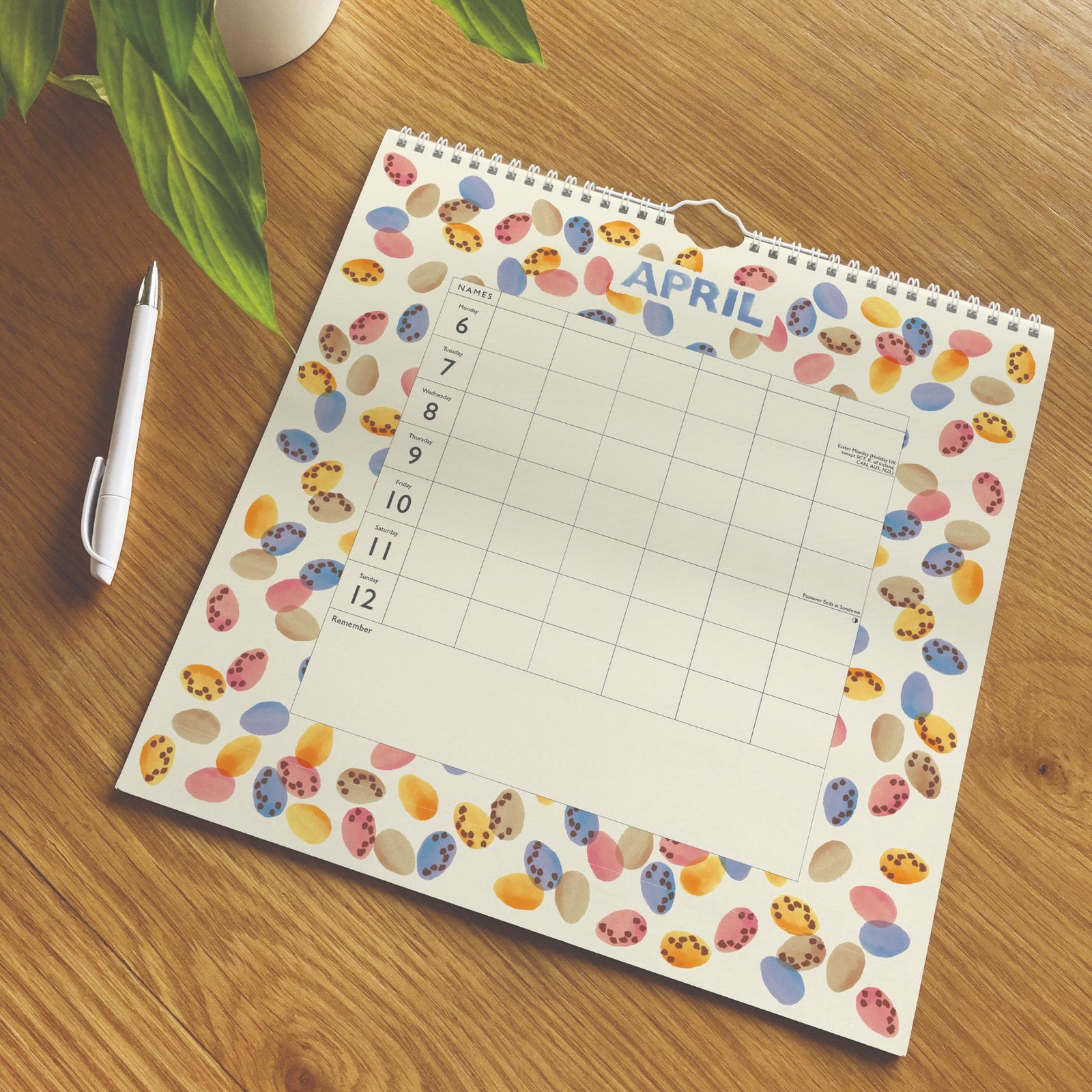 April calendar with Easter egg design on a wooden surface