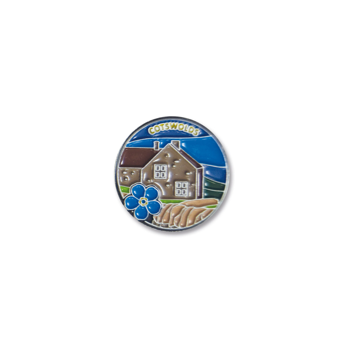 A round pin badge featuring an illustration of a Cotswold-style house with a bluebell flower in front, set against a blue sky background.