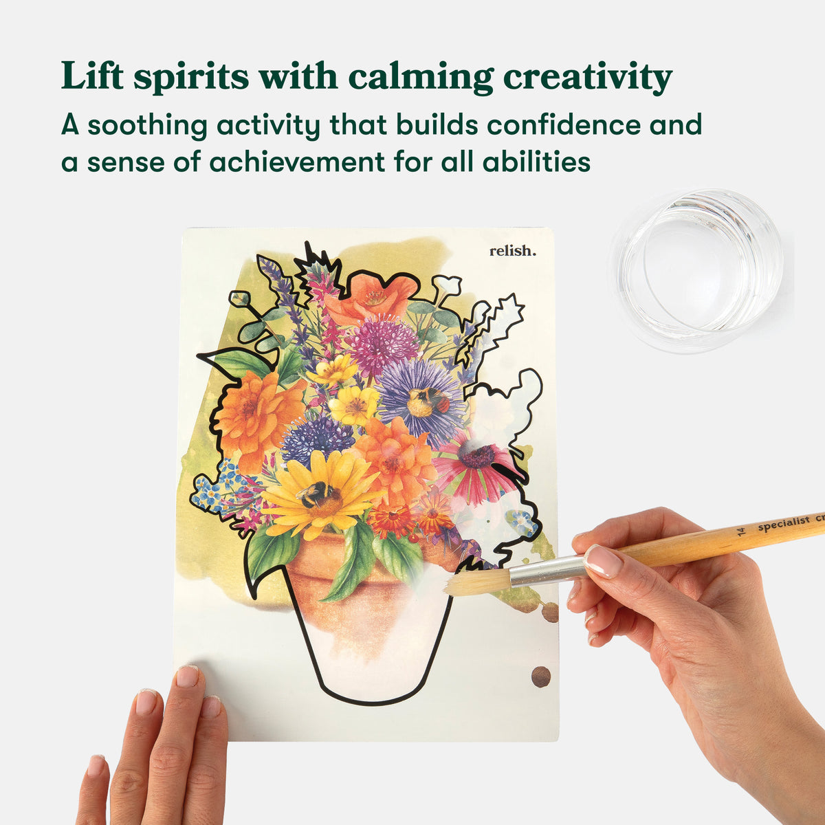 Person coloring a floral design with a paintbrush on a white surface, with text about calming creativity and confidence building.
