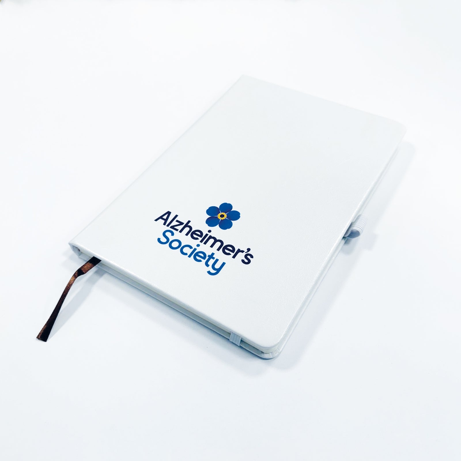 Notebook with Alzheimer's Society logo on a white background