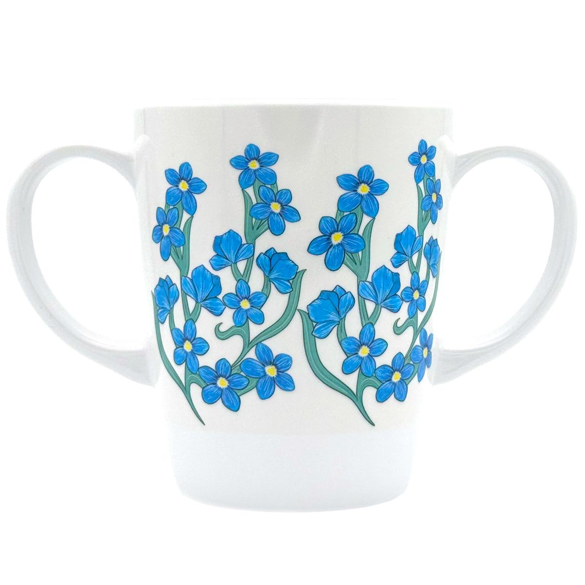 White mug with blue floral forget-me-not design on a white background