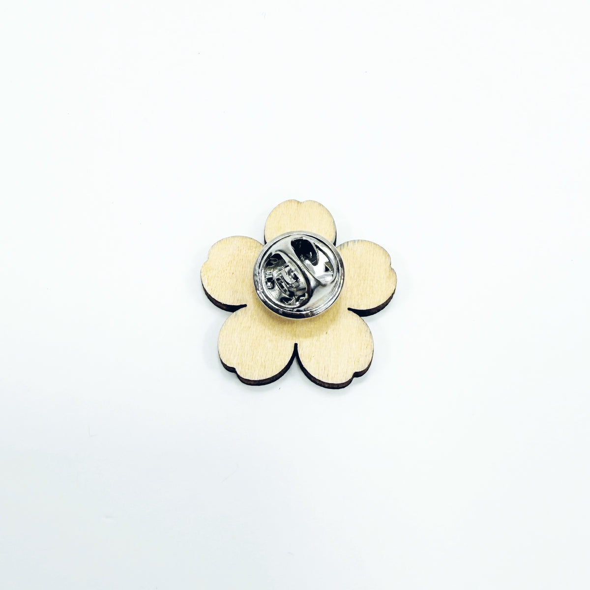 The back of a large wooden forget-me-not on a white background
