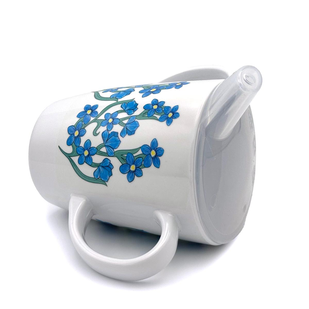 White mug with blue floral forget-me-not design on a white background with spouted lid