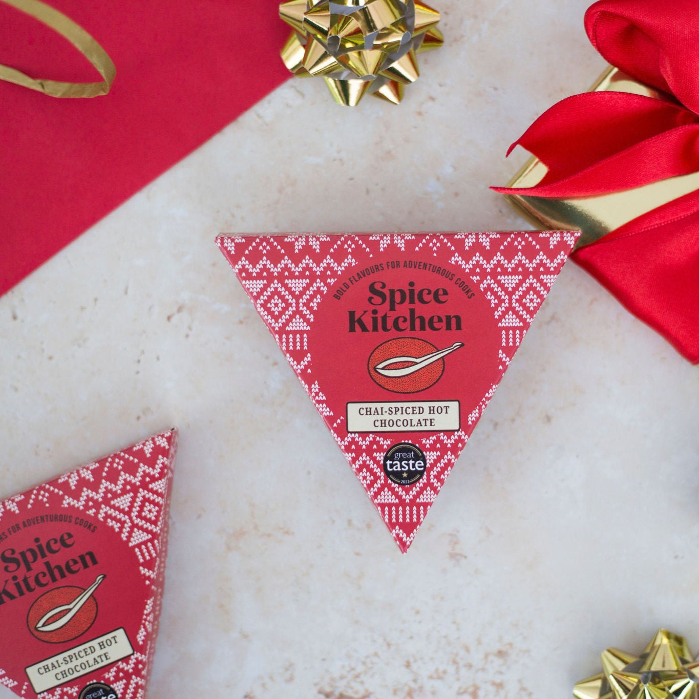 Spice Kitchen product packaging with decorative bows on a textured surface