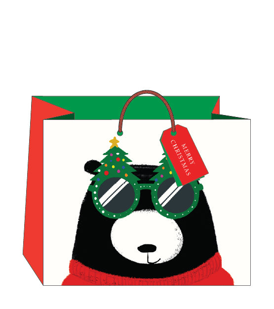Festive bear wearing christmas tree glasses landscape gift bag with tag on a white background.