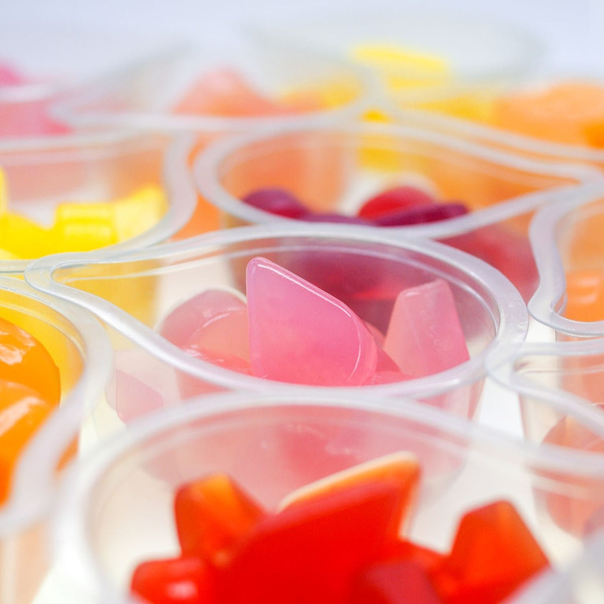 Multi-coloured fruit jelly drops in their clear pots