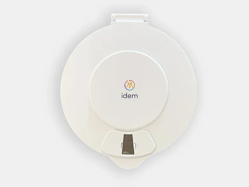 Idem pill dispenser with a white lid on a white background.