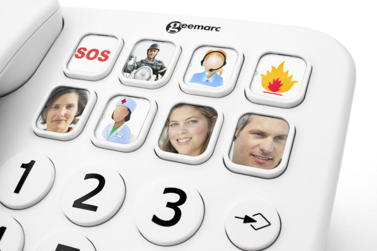 A close-up of a white emergency landline phone keypad with custom buttons showing faces and emergency icons, including SOS, police, ambulance, fire, and medical callers. The brand name Geemarc is printed at the top.