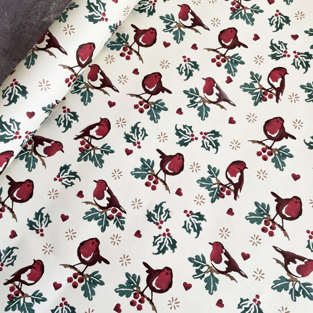 Christmas-themed paper with red birds, holly leaves, and berries on a white background.