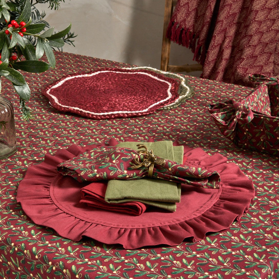 Festive table setting with a mistletoe patterned tablecloth.