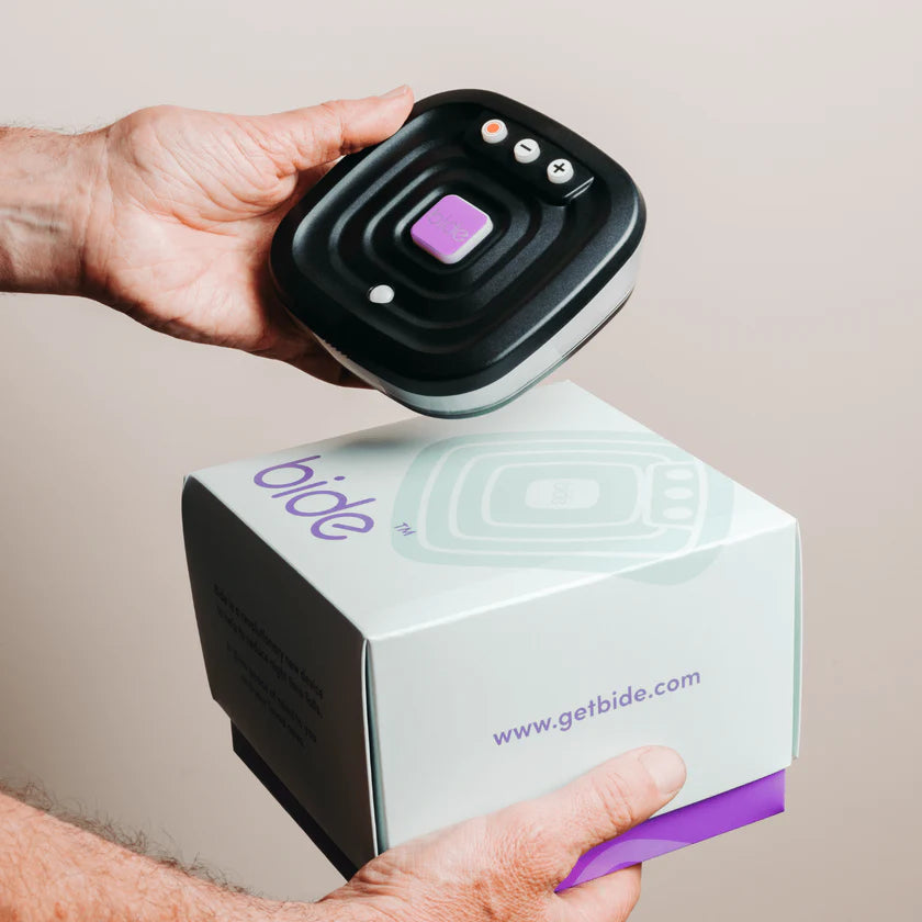 Person holding a black electronic device with purple accents above a 'bide' branded box.