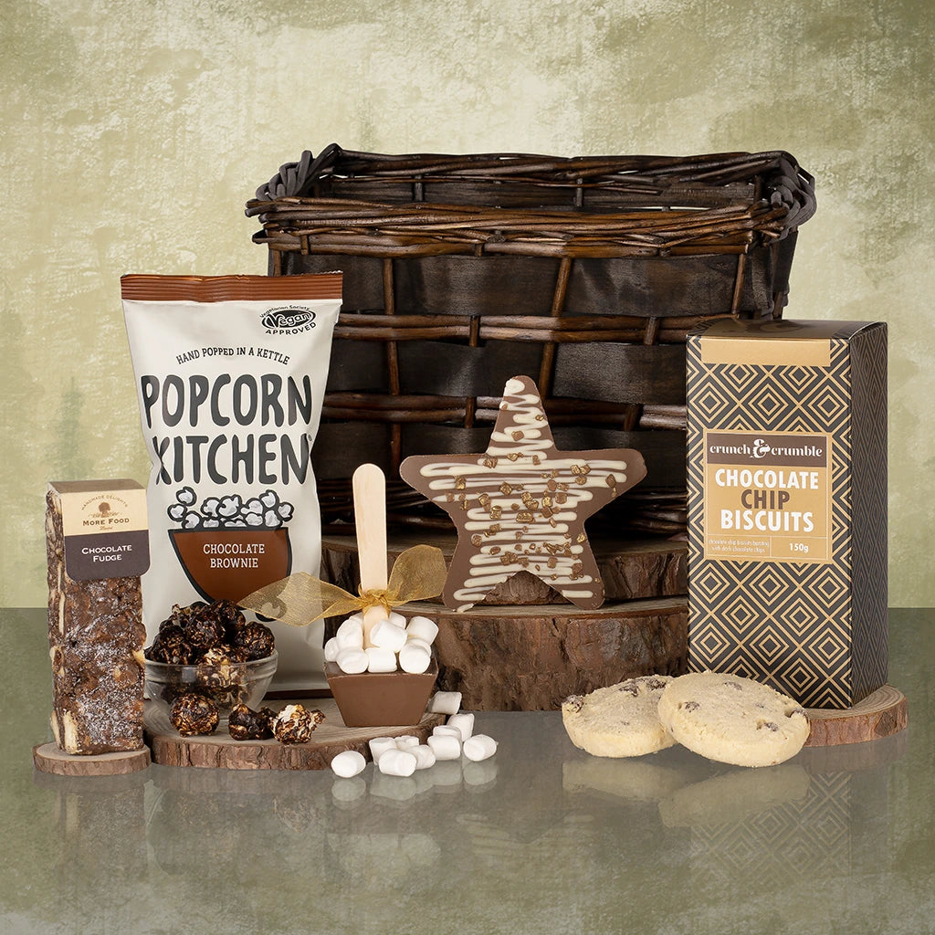 Chocolate-themed gift set with wicker basket, food items, and a star-shaped chocolate.