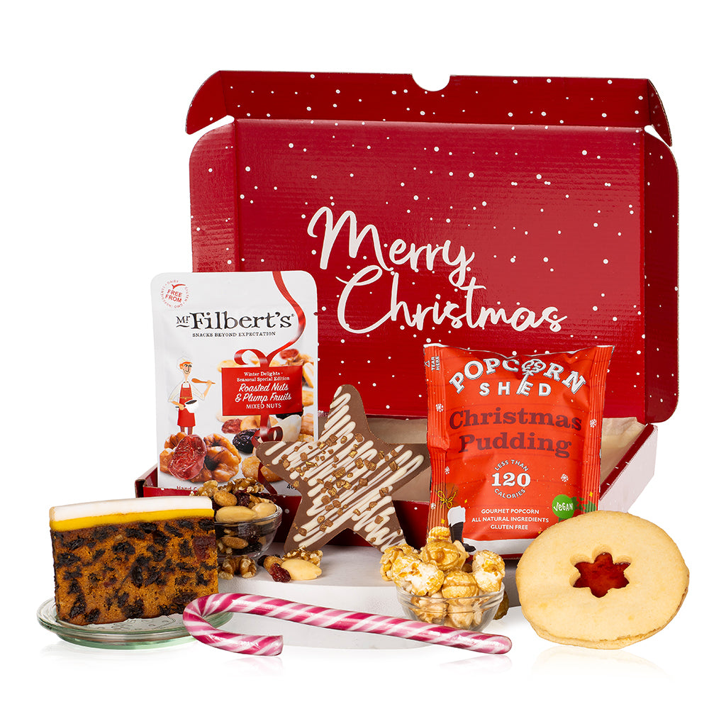 Christmas-themed gift set with festive packaging, food items, and a star-shaped cookie.