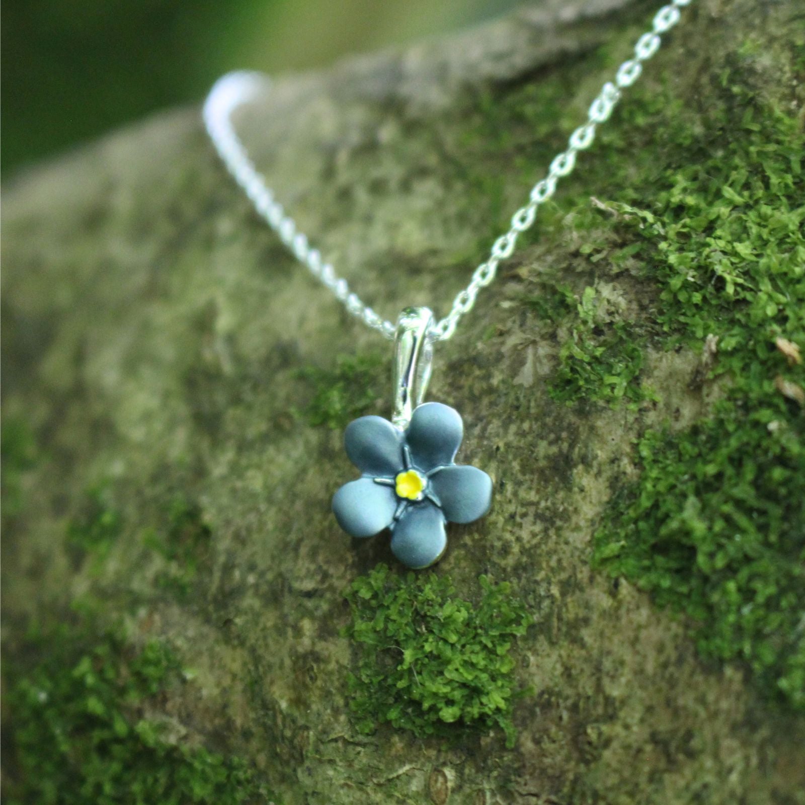 A blue Forget-me-not necklace on a branch