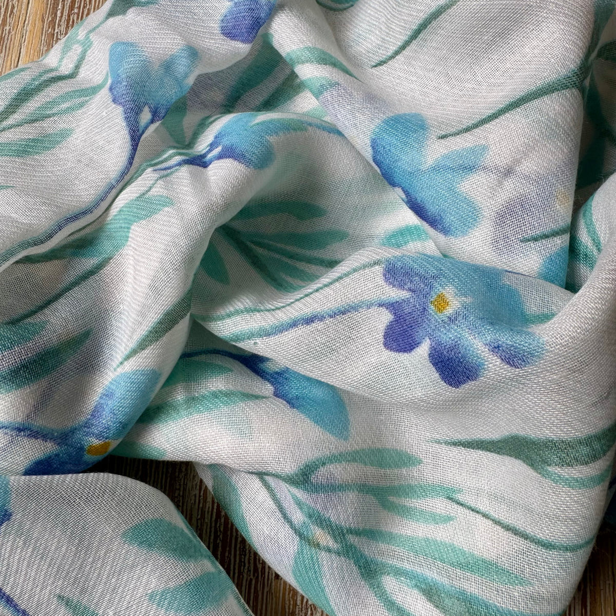 Fabric with blue floral pattern on a wooden surface