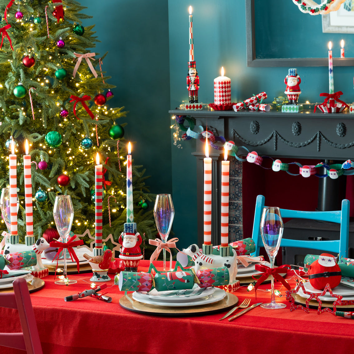 Decorated Christmas table with a tree, candles, and festive decorations.
