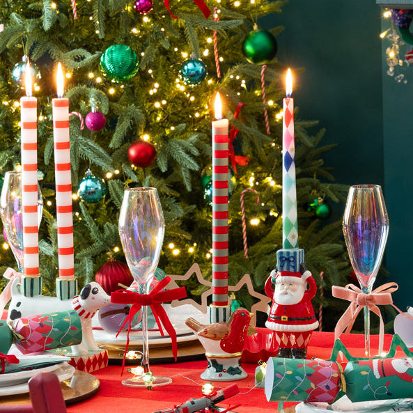 Decorated Christmas table with a tree, candles, and festive decorations.