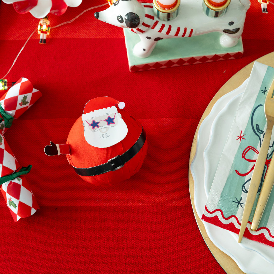 Red Santa hat on a red surface with Christmas decorations around