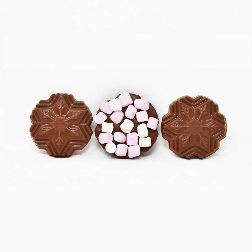 3 chocolate snowflakes out of the packet, with marshmallows on top of the middle one.