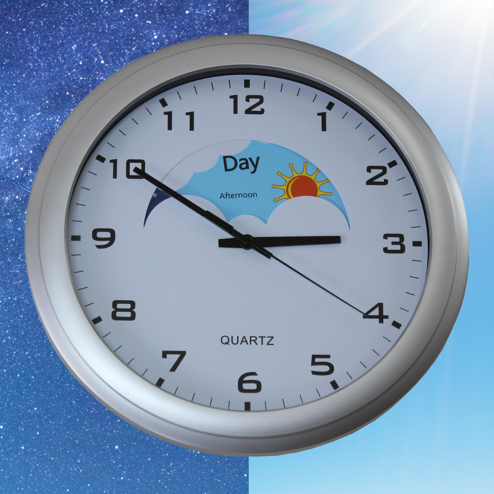 An analogue wall clock with day and night visual prompts, featuring a sun and moon on the face, clear print numbers, and bold hands. The clock is on an illustrated background featuring half starry sky and half sunny sky.