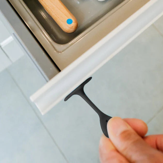 Hand using a black silicone grip to open a cabinet door.