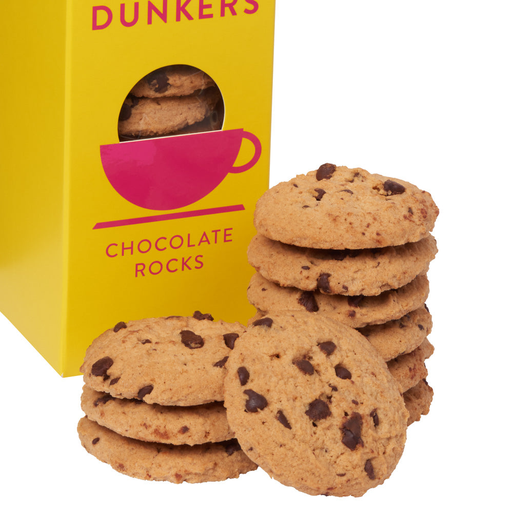 Chocolate Rocks cookie bars with visible chocolate chips, arranged in front of a bright yellow Dunkers branded box with a window showing more cookies.