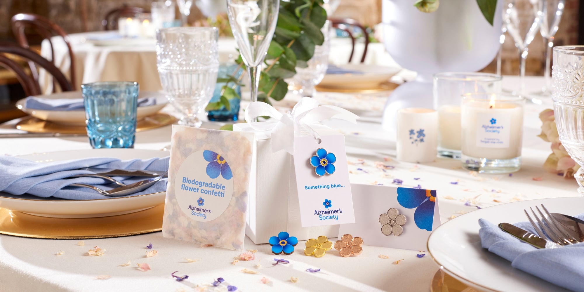A wedding table set with a collection of wedding favours such as pin badges, confetti and gift tags from Alzheimer's Society
