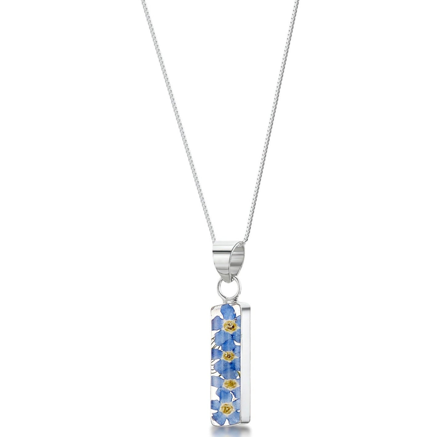 Sterling silver rectangle bar pendant with real forget-me-not flowers set in resin. Hangs on an 18" adjustable sterling silver chain.